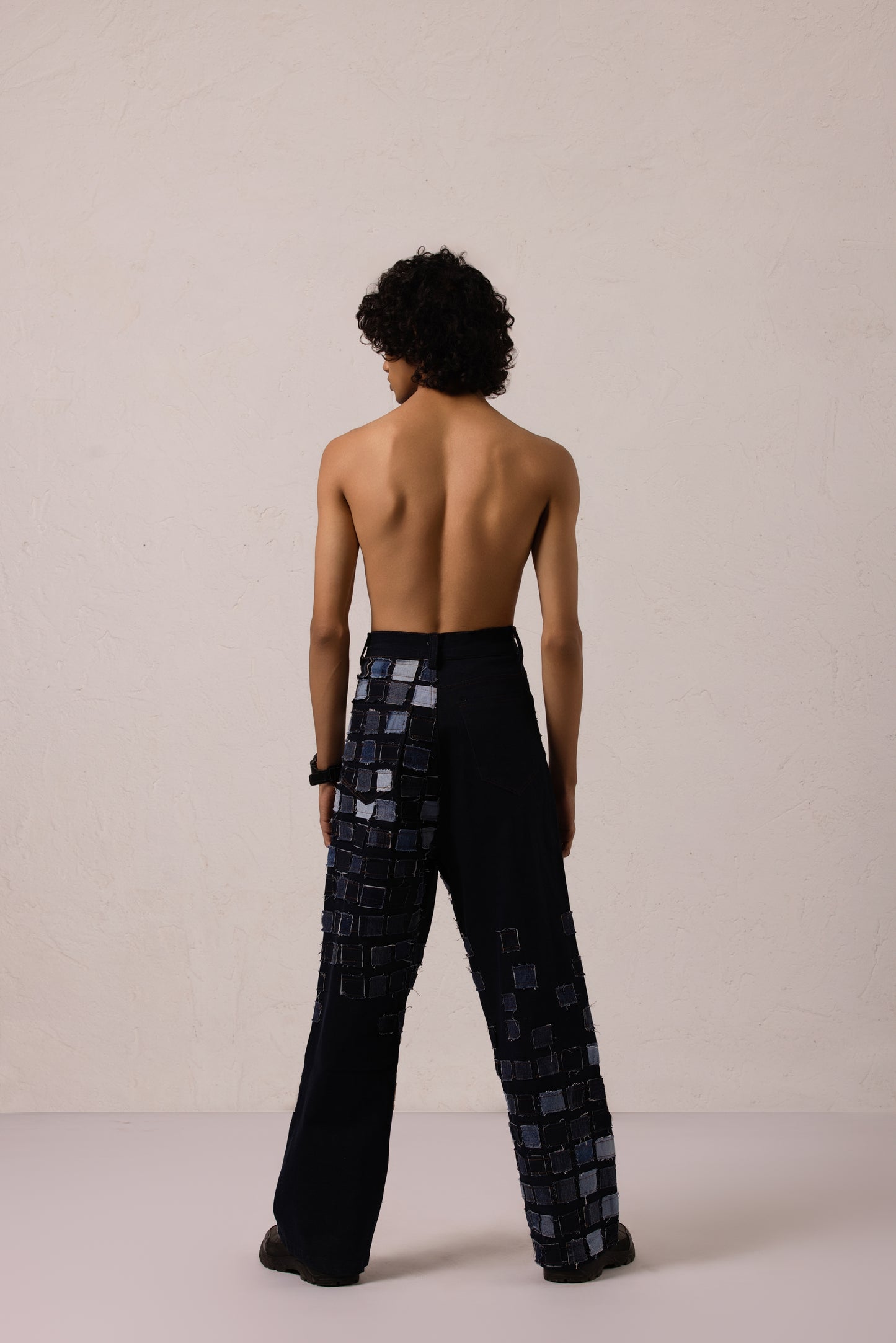 Model wearing baggy denim with sewn patches in a bold diagonal pattern, crafted from Denim Lycra