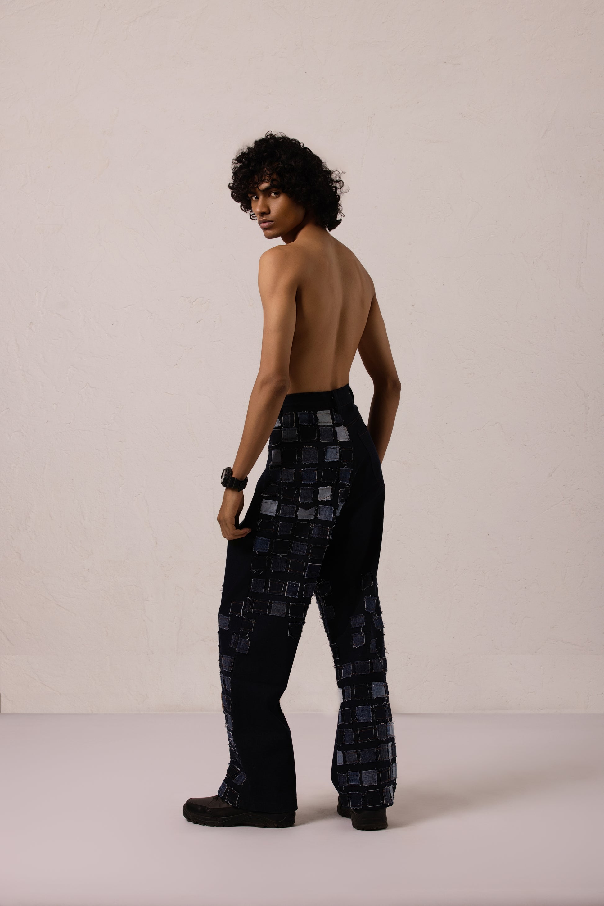 Model wearing baggy denim with sewn patches in a bold diagonal pattern, crafted from Denim Lycra