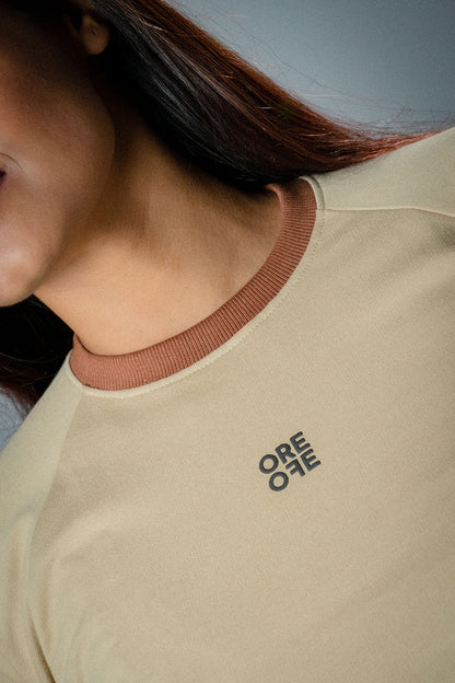 Female model wearing Beige basic crop top with logo of ORE OFE in focus