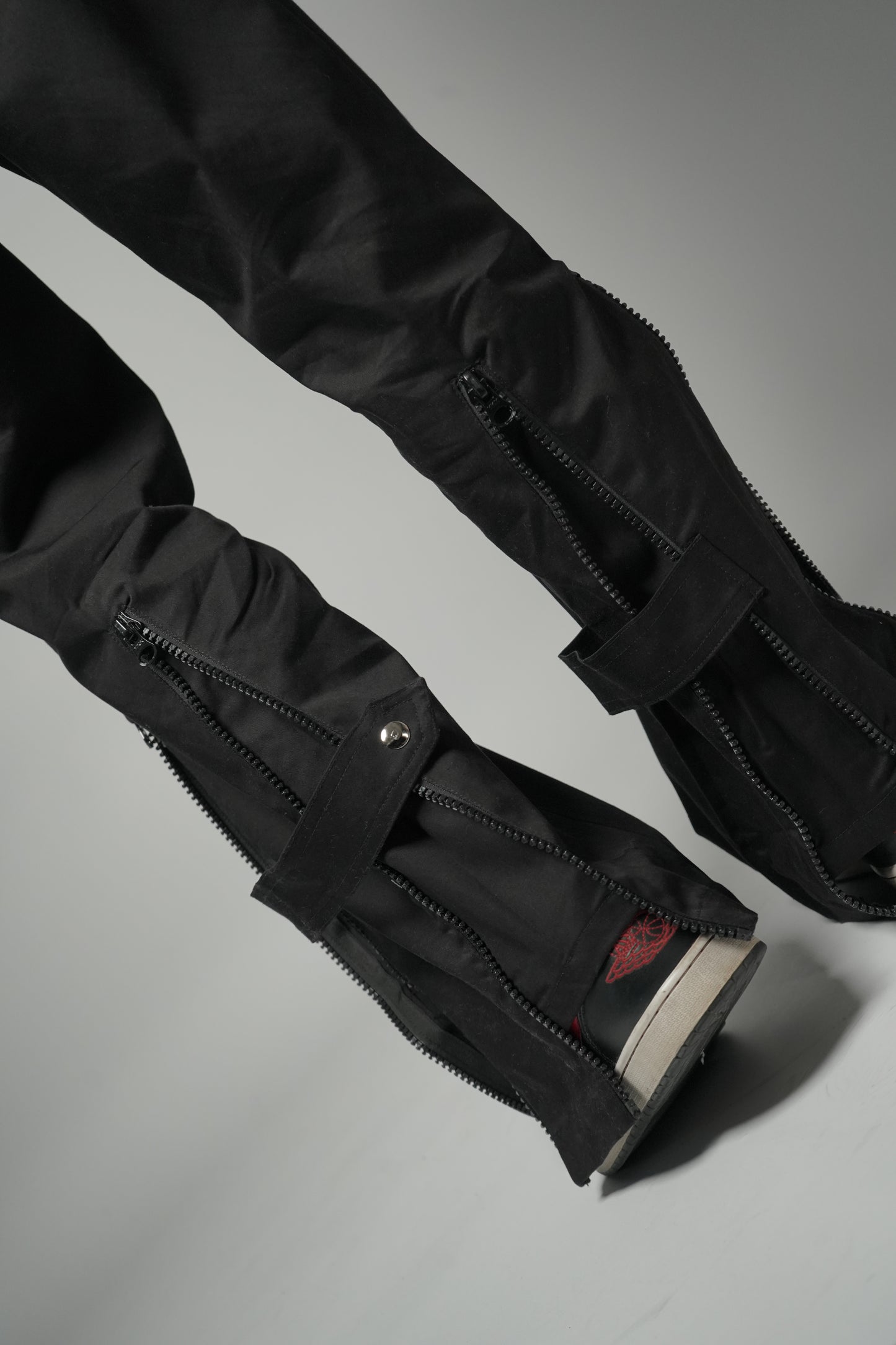 Model wearing Black Baggy Zipper Pants with Utility zips, leg-revealing zips, and back-flaring zips