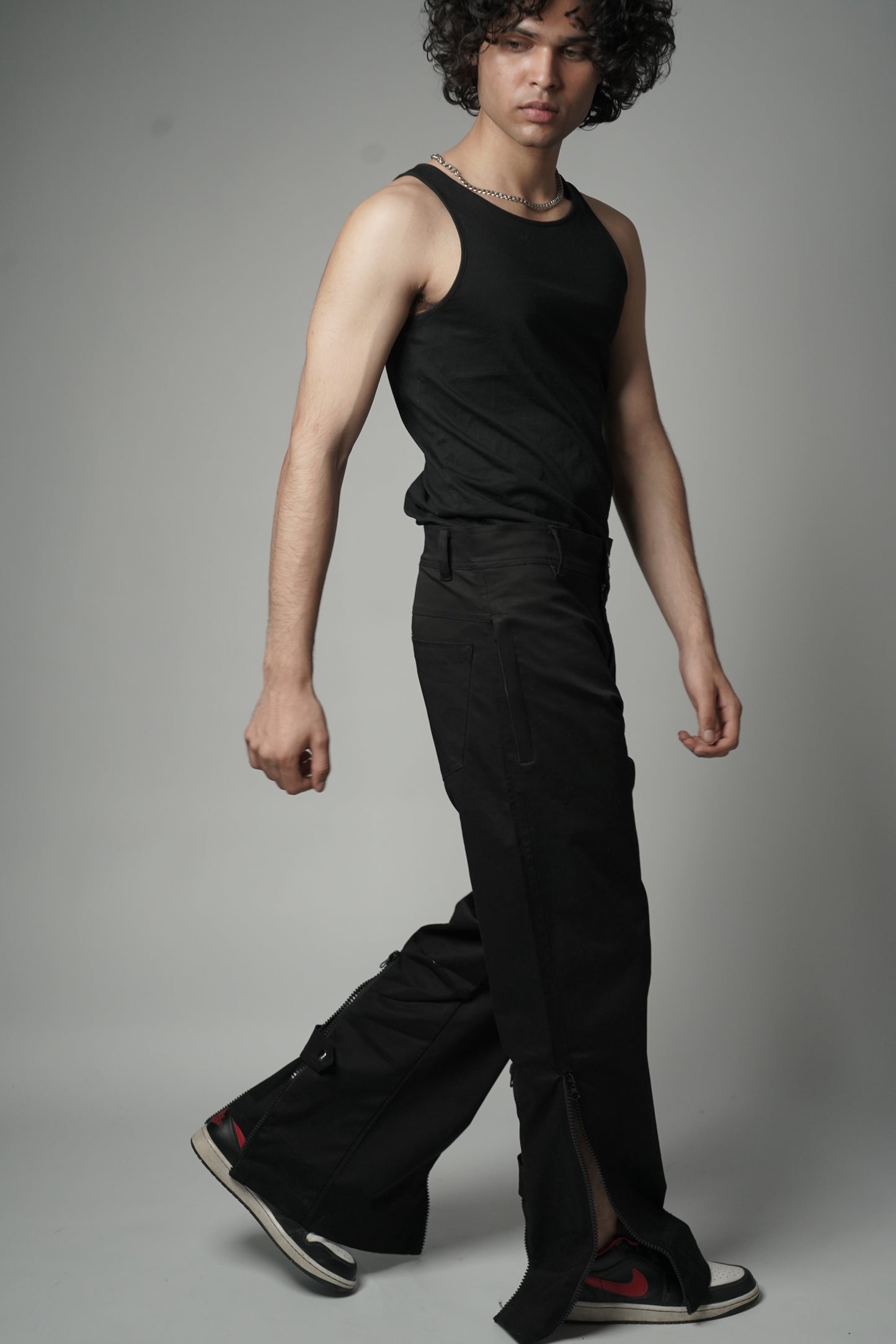 Model wearing Black Baggy Zipper Pants with Utility zips, leg-revealing zips, and back-flaring zips