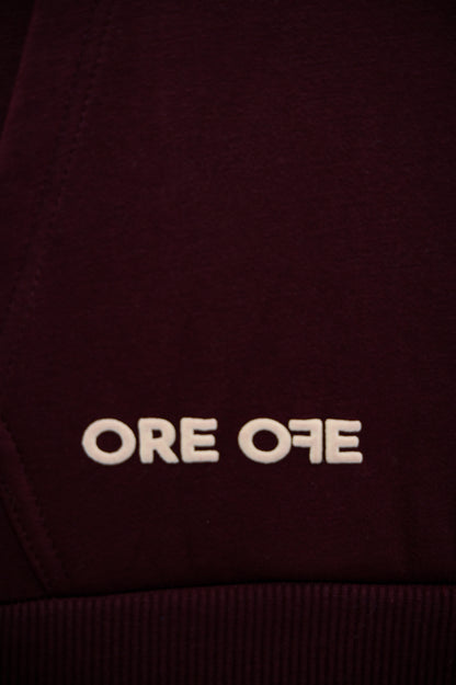 maroon hoodie with a contrasting dark grey hood features a cat strumming the shamisen