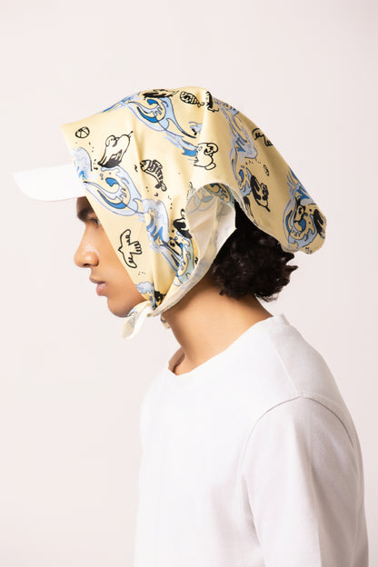 Model wearing the Surf Up Multi-purpose Bandana as a headband, featuring a surfing dog design, made from 100% cotton.