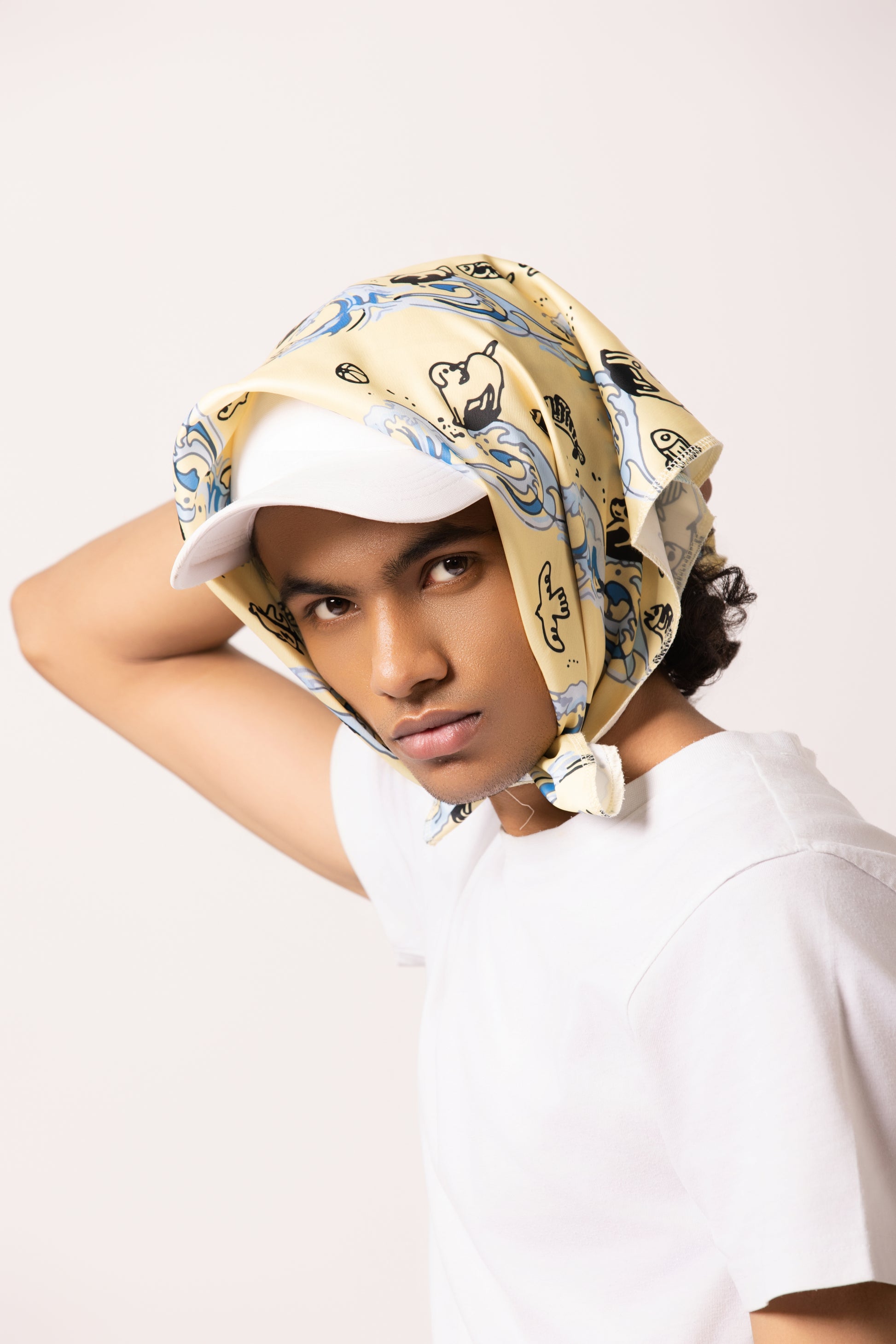 Model wearing the Surf Up Multi-purpose Bandana as a headband, featuring a surfing dog design, made from 100% cotton."