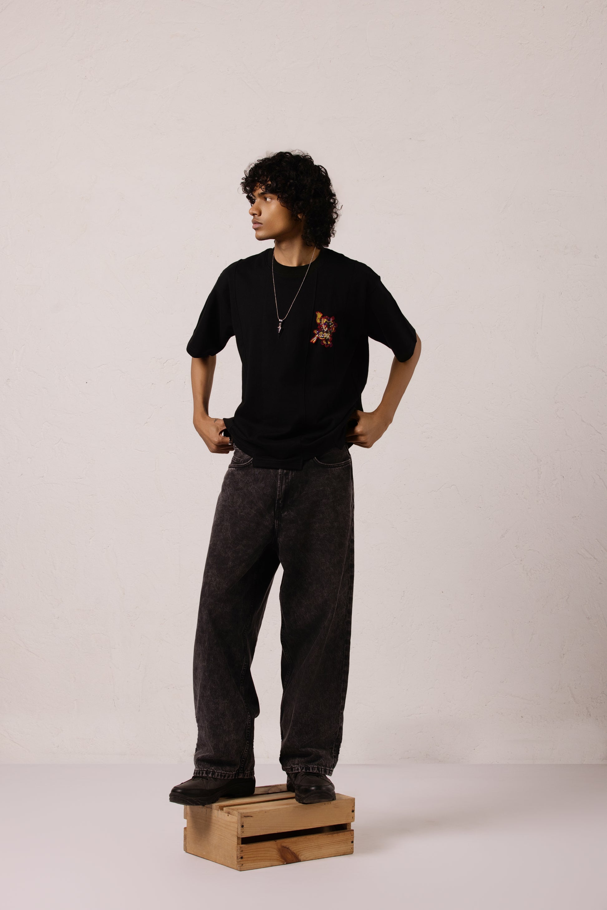 Model wearing Xolotl black Oversized T-shirt with Aztec dog god design, 100% Terry Cotton, embroidery & screen printing.